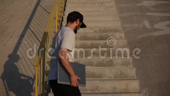 年轻的自由职业者带着笔记本电脑来坐在城市楼梯上开始工作视频的预览图