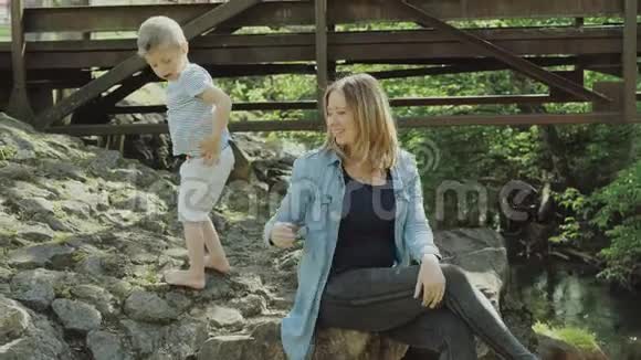 漂亮的年轻妈妈和活泼可爱的金发男孩在玩玩得很开心女人爱她的儿子漂亮的年轻妈妈视频的预览图