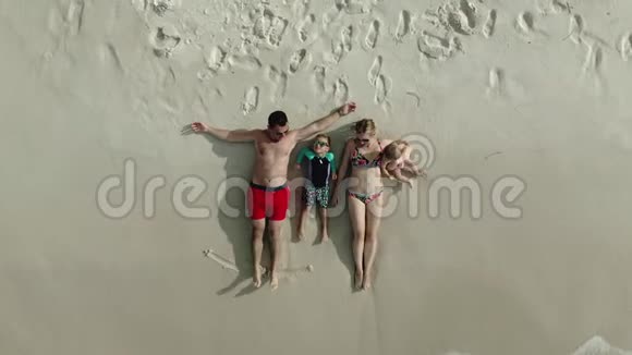 一家人躺在沙滩上鸟瞰无人机射击视频的预览图