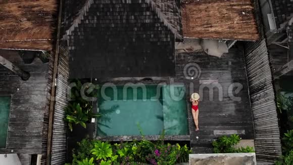 空中无人机在豪华别墅的私人游泳池附近放松俯瞰着无法辨认的女人视频的预览图