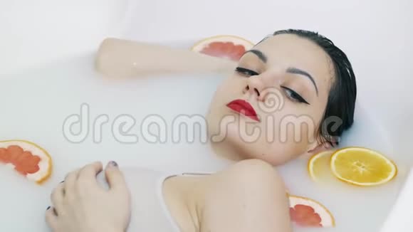 性感的女人沐浴在充满水果的牛奶浴中放松水疗和护肤理念视频的预览图
