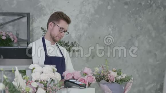 年轻花店男画像男卖家把花束卖给金发个金发女郎女人在视频的预览图