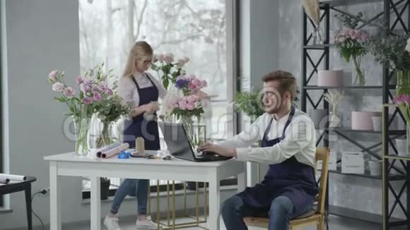 鲜花递送年轻的现代专业花店在鲜花店工作坐在那里通过电话接受订单视频的预览图