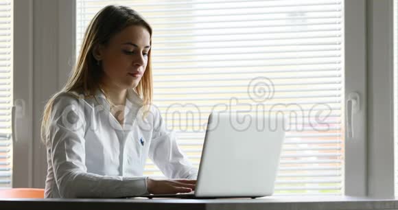 一个年轻女人反应迟钝的笔记本电脑视频的预览图