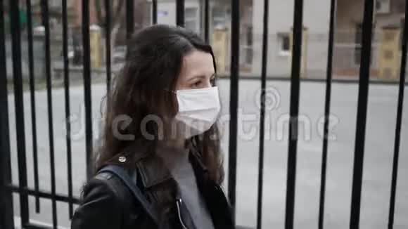 年轻女子戴着医疗面具在城里散步成年女性用面具遮住她的脸保护自己免受疾病的侵袭视频的预览图