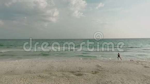 穿比基尼的女人的俯视图沿着海滩度假时海洋附近苗条女士的鸟瞰图视频的预览图