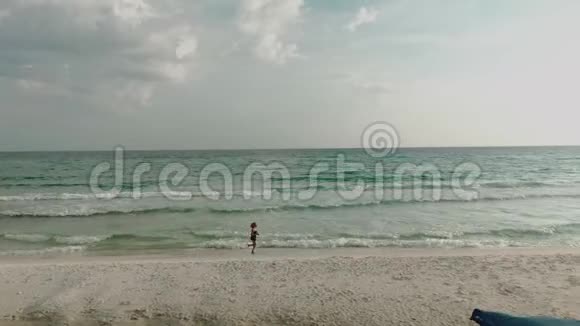 穿比基尼的女人的俯视图沿着海滩度假时海洋附近苗条女士的鸟瞰图视频的预览图