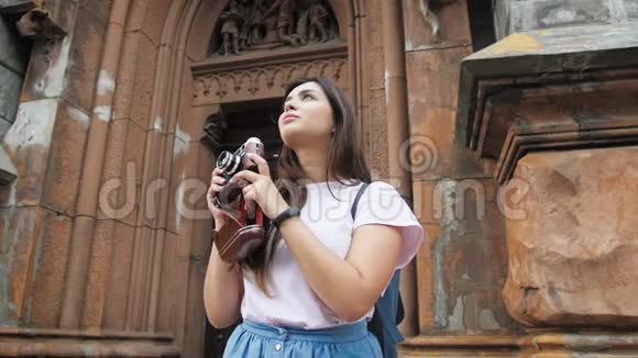 慢镜头视频年轻的微笑妇女制作老城的照片手动胶卷相机视频的预览图