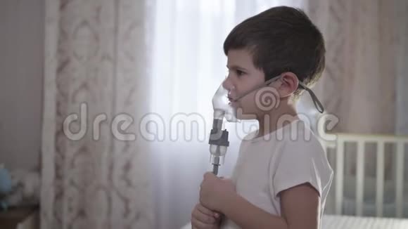 生病的孩子在家里通过吸入面罩吸入通过雾化器治疗气道炎症以预防哮喘和视频的预览图