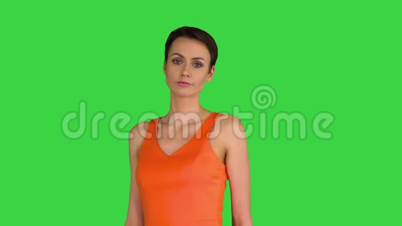 剪短的漂亮女人在绿色屏幕上的橙色阳光下跳舞Chroma键视频的预览图