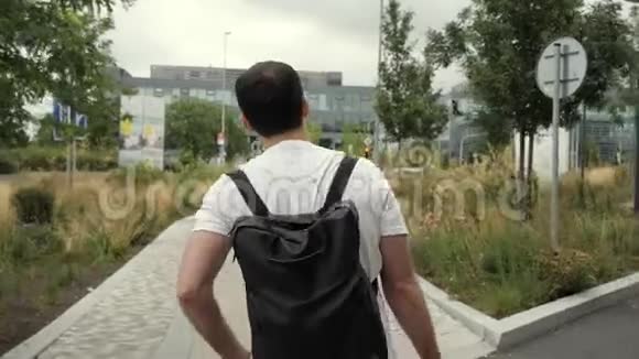 成年白种人背着背包走在城市户外的街道上视频的预览图