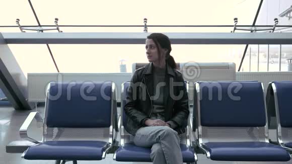 机场的美女正坐在椅子上等飞机视频的预览图