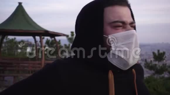 戴着面具的年轻人在公园咳嗽视频的预览图