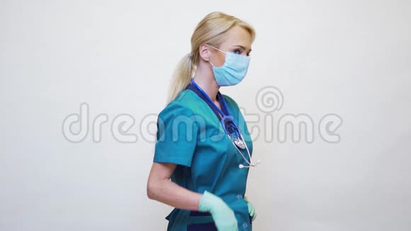 戴防护面罩橡胶或乳胶手套的女医生停止手势视频的预览图