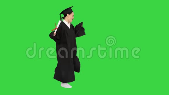 穿着毕业长袍的白人妇女在绿色屏幕上跳舞ChromaKey视频的预览图
