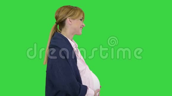 孕妇在绿色屏幕上行走微笑铬钥匙视频的预览图