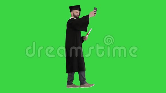 成熟的研究生一边自拍一边走在绿色的屏幕上色度键视频的预览图