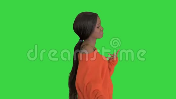 美丽的黑人妇女在绿色屏幕上微笑和跳舞Chroma键视频的预览图