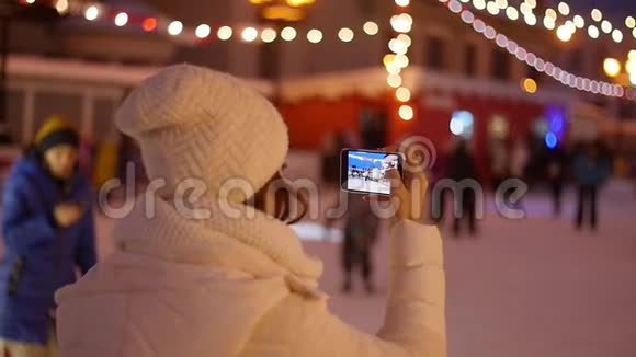 在智能手机上拍摄欧洲圣诞市场场景的快乐女人视频的预览图