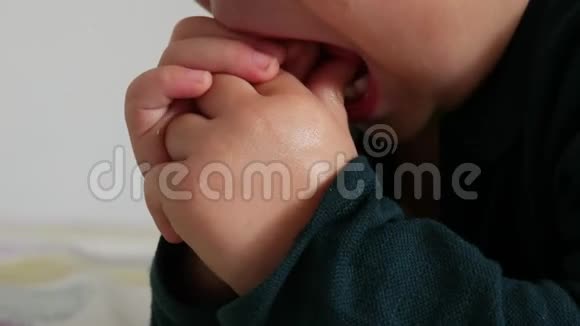 一个可爱的婴儿把手指伸进嘴里的特写镜头视频的预览图