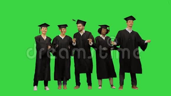 活泼的女孩和男孩毕业的学生在绿色屏幕上跳舞Chroma键视频的预览图
