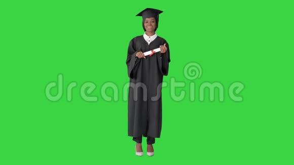 美丽的美国黑人女毕业生在绿色屏幕上微笑色度键视频的预览图