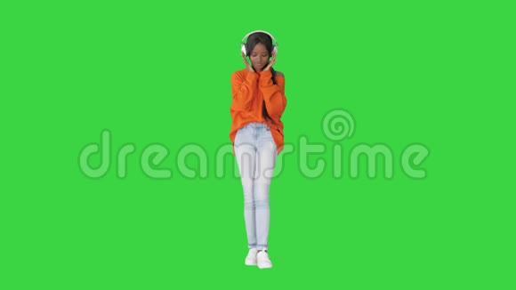 快乐美丽的年轻非洲裔美国妇女听音乐在她的耳机上的绿色屏幕Chroma键视频的预览图