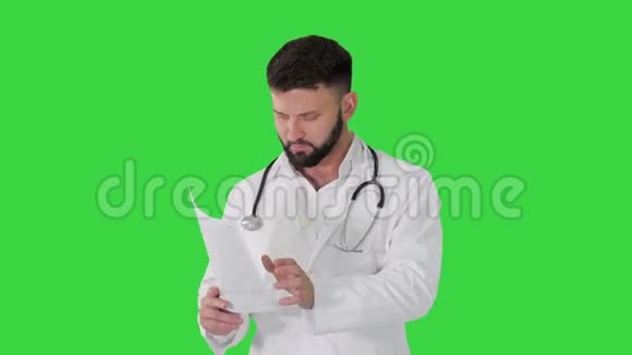 白种人严肃的医生在绿色屏幕上行走和解释心脏图Chroma键视频的预览图
