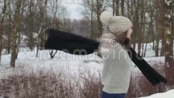 手持式射击美丽快乐的模特女孩在冬日公园欢笑嬉戏户外美女视频的预览图