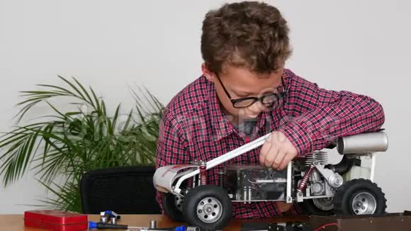 小男孩在家修理一辆无线电控制的汽车模型视频的预览图
