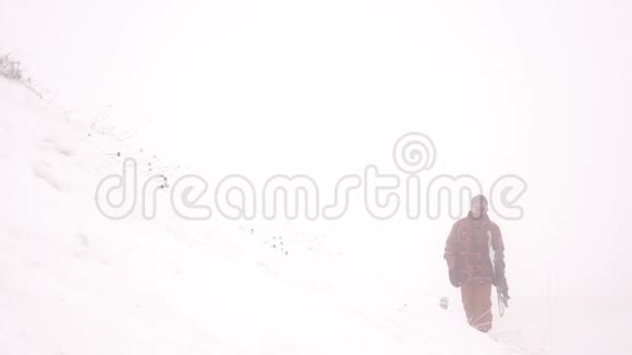 滑雪者穿过暴风雪举着一块木板视频的预览图