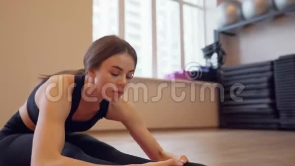 美丽的年轻女子在室内锻炼和伸展视频的预览图