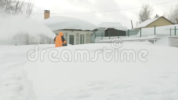 一个人在雪堆后面用抛雪机扫雪视频的预览图