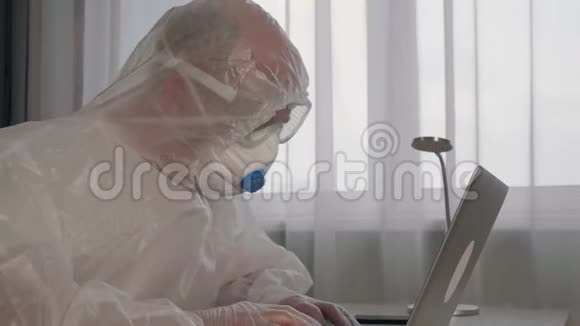 病毒学家穿着防护服用笔记本电脑工作视频的预览图