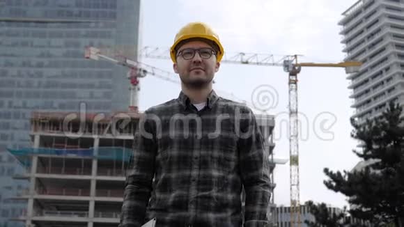 英俊的建筑师戴着安全帽从建筑工地走出来视频的预览图