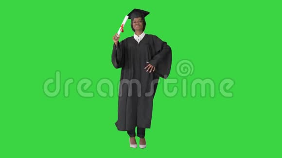 快乐的非洲毕业女学生在绿色屏幕上跳舞Chroma键视频的预览图