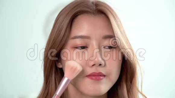 特写亚洲美女在脸上刷粉底贴合工艺唇膏唇彩视频的预览图