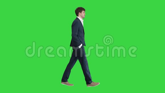 英俊的商人手拿口袋走在绿色屏幕上Chroma键视频的预览图
