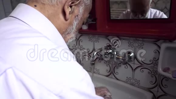一名土耳其老人在老式浴室洗手的追踪镜头视频的预览图