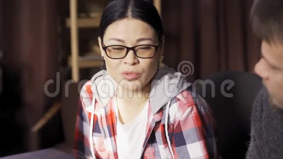 穿格子衬衫的漂亮亚洲女人坐在车间策划组视频的预览图