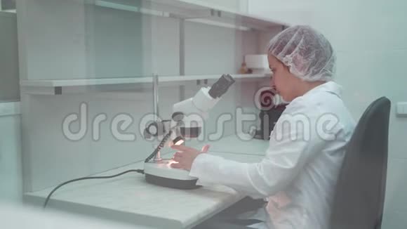 女科学家开始使用显微镜微生物学家看显微镜微生物实验室研究视频的预览图