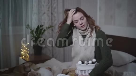 女人喉咙痛咳嗽和打喷嚏女孩喝了一片药而坐在床上用餐巾纸和视频的预览图
