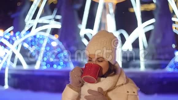 年轻快乐的女人在圣诞节装饰中在户外喝咖啡或覆盖葡萄酒视频的预览图