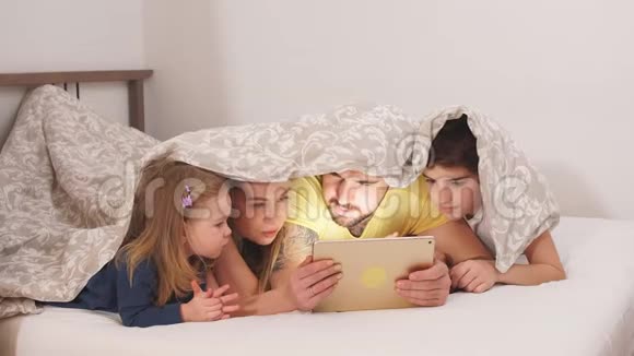情感友好的家庭喜欢在床上看电影视频的预览图