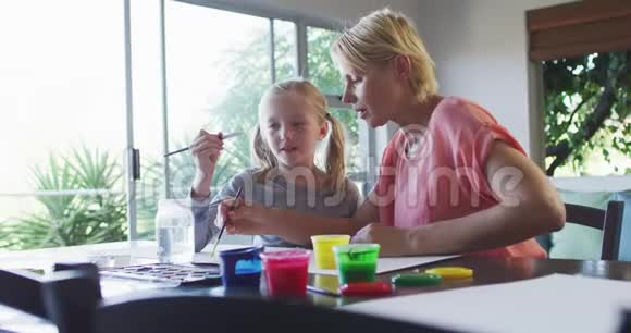 白种人妇女与女儿在家绘画的侧视图视频的预览图