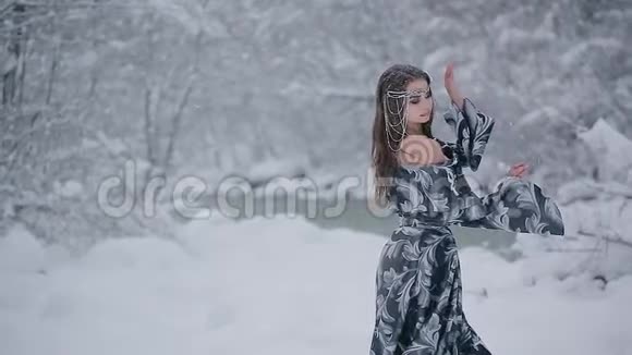穿着灰色皇家服装的可爱少女站在雪地里视频的预览图