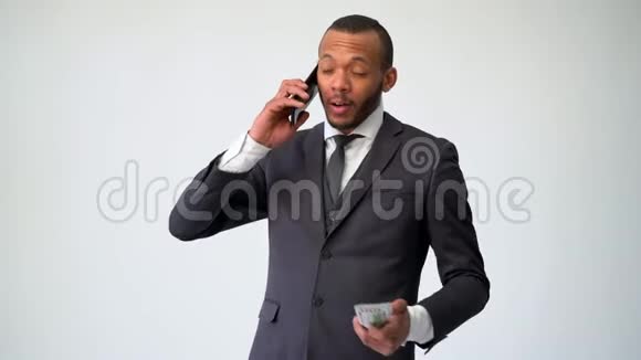 专业的非裔美国人商人用手机说话手里拿着现金视频的预览图