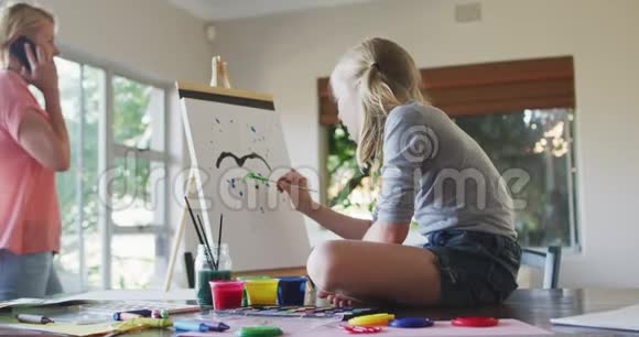 白种人女孩与母亲在家绘画的侧视视频的预览图