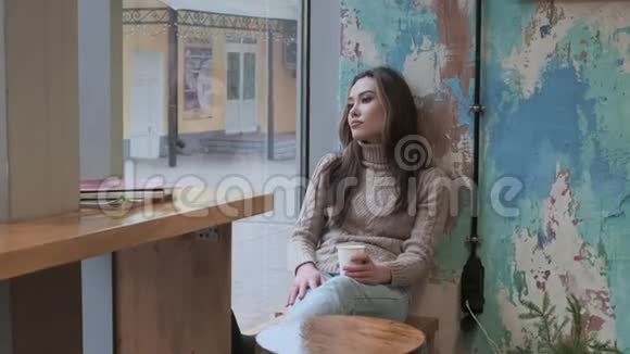 时尚体贴的年轻亚洲美女坐在咖啡馆端着一杯咖啡视频的预览图