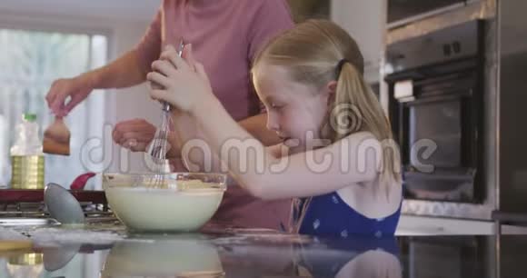 白种人女孩和母亲在家做饭的侧视图视频的预览图